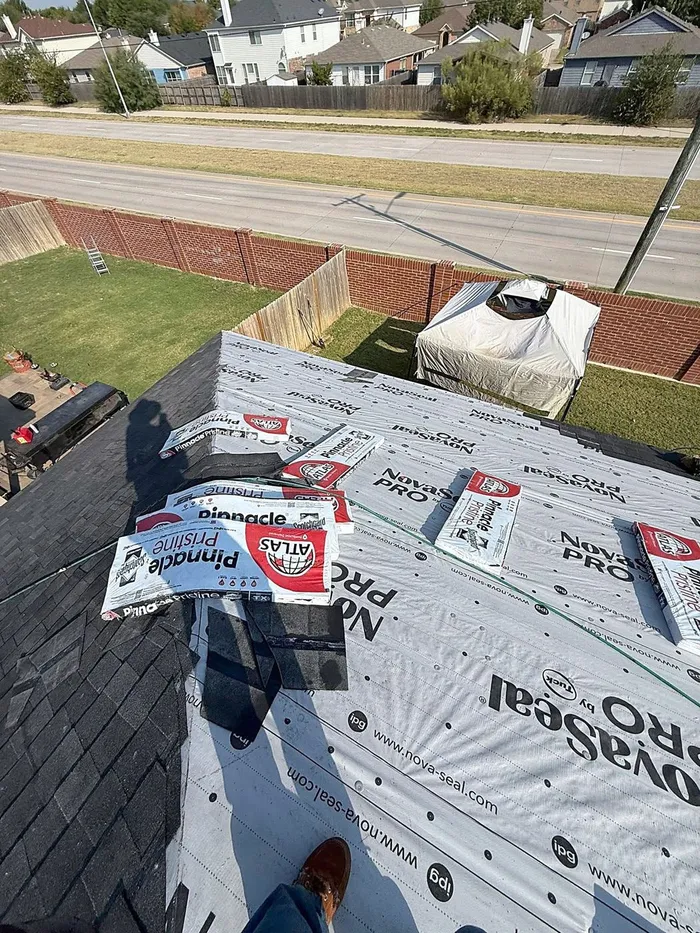 Atlas Pinnacle Pristine shingle bundles staged on new underlayment